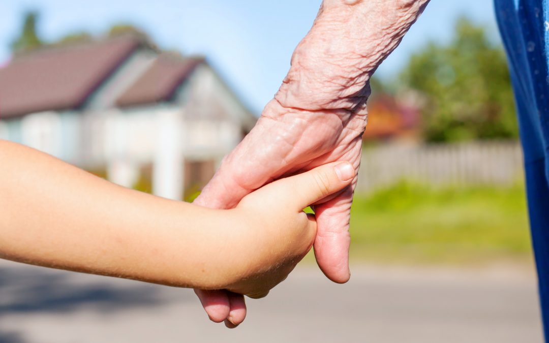 grandmother taking hand of young child
