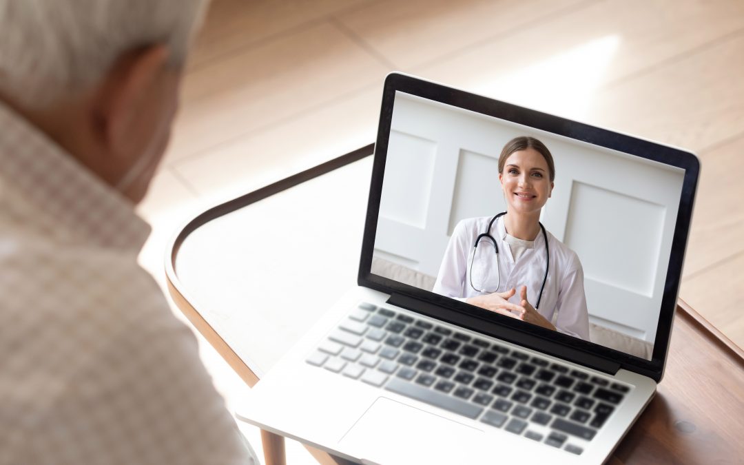 Close up of modern elderly man sit at home having online consultation with doctor on computer